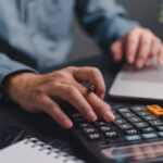 Businessman using calculator bookkeeping payroll and budget tax. Business document finance accounting investment