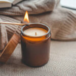 Girl lights a candle, aesthetic cozy photo.
